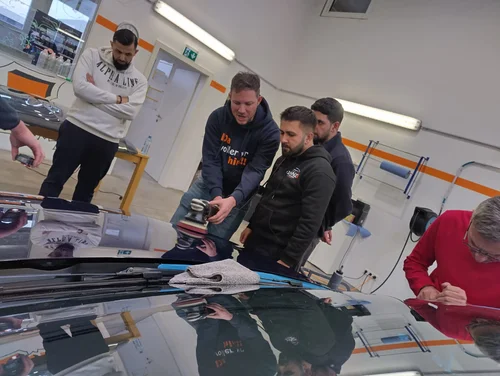 Gruppe von Autoaufbereitern üben das Polieren
